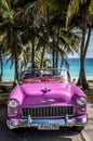 HDR Cuba pink american Oldtimer parked under palms near the beach in Varadero Royalty Free Stock Photo