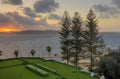 HDR image of a sunset on the horizon behind three trees and a sea Royalty Free Stock Photo