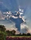 HDR image of a tall cloud with sunbeams Royalty Free Stock Photo