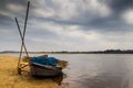 HDR landscape of a boar tied at the corner of river bed sandy beach and cloudy sky day time scene. Royalty Free Stock Photo