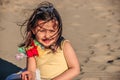 Little girl at beach, summer dressed child girl poses very well on the sand