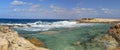 HDR panorama photo of a sunny day at the rocky sea coast with deep blue clean water and small rock formations Royalty Free Stock Photo