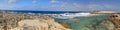 HDR panorama photo of a sunny day at the rocky sea coast with deep blue clean water and small rock formations Royalty Free Stock Photo