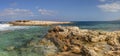 HDR panorama photo of a sunny day at the rocky sea coast with deep blue clean water and small rock formations Royalty Free Stock Photo