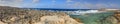 HDR panorama photo of a sunny day at the rocky sea coast with deep blue clean water and small rock formations Royalty Free Stock Photo