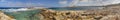 HDR panorama photo of a sunny day at the rocky sea coast with deep blue clean water and small rock formations Royalty Free Stock Photo