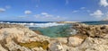 HDR panorama photo of a sunny day at the rocky sea coast with deep blue clean water and small rock formations Royalty Free Stock Photo