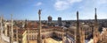 HDR panorama photo of white marble statues of Cathedral Duomo di Milano on piazza, Milan cityscape and the Royal Palace of Milan