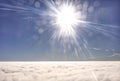 HDR photo of an airplane wing against the blue sky with a cloud cover underneath and brigh shining sun in in front of it Royalty Free Stock Photo