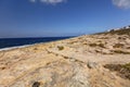 HDR photo of a sunny day at the sea coast with deep blue clean water and a nice stone beach and vegetation growing there Royalty Free Stock Photo