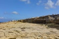 HDR photo of a sunny day at the sea coast with deep blue clean water and a nice stone beach and vegetation growing there Royalty Free Stock Photo