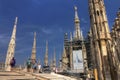 HDR photo of he white marble statues and decorations on the Cathedral Duomo di Milano on piazza in Milan with visitors