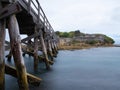 A wooden foot crossing bridge in La Perouse Sydney Botany Bay Australia on a cloudy dark rainy afternoon Royalty Free Stock Photo