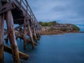 A wooden foot crossing bridge in La Perouse Sydney Botany Bay Australia on a cloudy dark rainy afternoon Royalty Free Stock Photo