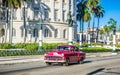 HDR - Street life view with american brown red Chevrolet vintage car drive before the Capitolio on the main street in Havana City Royalty Free Stock Photo