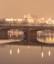 HDR winter photo of a bridge across Vltava river reflecting on the water surface and the Prague castle in the background Royalty Free Stock Photo