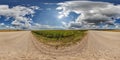 hdri 360 panorama of blue sky with awesome clouds on roadside of gravel road among fields in equirectangular full seamless Royalty Free Stock Photo