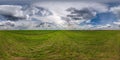360 hdri panorama on green grass farming field with clouds on overcast sky before sunset in equirectangular spherical seamless Royalty Free Stock Photo