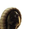Head of black abstract female mannequin in knitted winter hat on white background