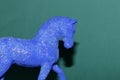 head and body part of a blue horse on a green background