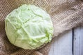 Head of cabbage on sackcloth, white wooden table Royalty Free Stock Photo