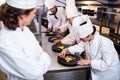 Head chef overlooking other chef decorating dish Royalty Free Stock Photo