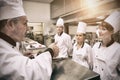 Head chef rating plate of one of his apprentices Royalty Free Stock Photo