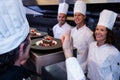 Head chef showing his thumbs up after inspecting dessert plates Royalty Free Stock Photo