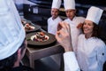 Head chef showing ok hand sign after inspecting dessert plates Royalty Free Stock Photo