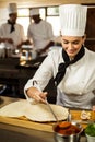 Head chef spreading sauce on a pizza