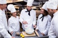Head chef teaching his team to prepare a dough Royalty Free Stock Photo