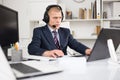 Head of the company conducts online negotiations with business partners in headphones