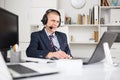 Head of the company conducts online negotiations with business partners in headphones