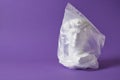 head of david in a transparent plastic bag on a purple background copy space Royalty Free Stock Photo