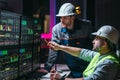 Head engineer and worker following factory production line uses screens with Industry 4.0 software. Couple of facility operators