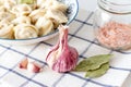 Head of garlic and bay leaf on the background of a plate with dumplings Royalty Free Stock Photo