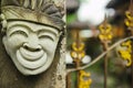 Head of a Hindu deity stone statue of a person with a smile on the background of a fence.