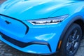 head lights of Electric Ford Mustang Mach-E on display in parking lot of company store specializing in sale of electric vehicles,