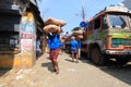 Head load workers unloading gunny bags from a truck in the market