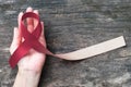 Head and neck cancer awareness with burgundy ivory color ribbon on helping hand support, symbolic bow color for Oral Squamous Cell Royalty Free Stock Photo