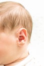 Head of the newborn baby first hear on white background, baby ear close up, macro shot of the hearing aid, earache, Royalty Free Stock Photo