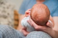 Head of a newborn close up. The father holds in the hands of the infant and copy space. Baby care concept Royalty Free Stock Photo