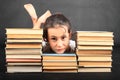 Head of sad teenage girl leaning on old books