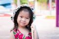 Head short. Cute girl is smiling at the camera. Children hold a folded umbrella. Child wearing hat polka dot. Asian kid 3 years