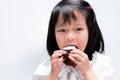 Head shot. Asian child girl eating chocolate sweet bakery lusciously. Kid happiness biting cake Royalty Free Stock Photo