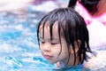 Head shot. Asian child girl playing water in the pool. Family travel resort in holiday. Portrait of baby like swimming. Royalty Free Stock Photo