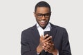 Head shot cheerful millennial african american guy holding smartphone.