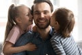 Head shot close up cheerful little kids siblings kissing father. Royalty Free Stock Photo