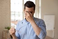 Employee suffering from dry eyes syndrome or eyestrain. Royalty Free Stock Photo