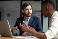 Focused businessman listening to young african american employee. Royalty Free Stock Photo